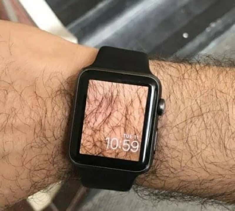 A smartwatch displaying a close-up of hairy skin on the wrist.