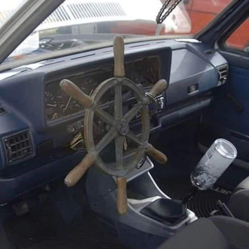 Steering wheel made from a ship's wheel inside a vehicle dashboard.