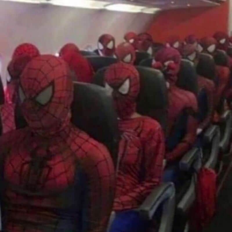 Spiderman costumes on passengers in an airplane cabin, all wearing full masks and suits.