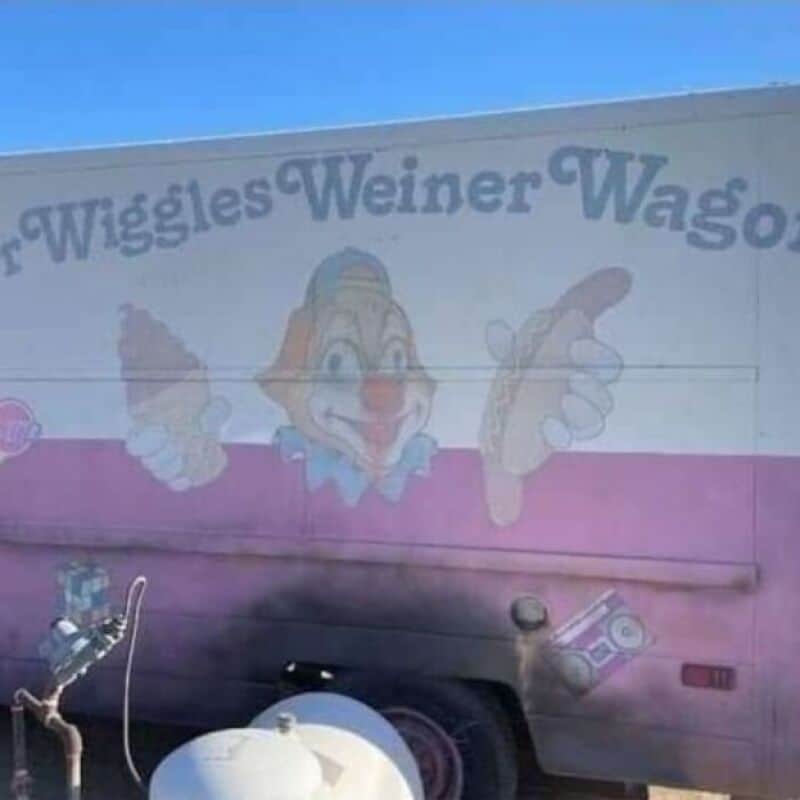 "Clown face with a red nose and big smile on a colorful wagon".