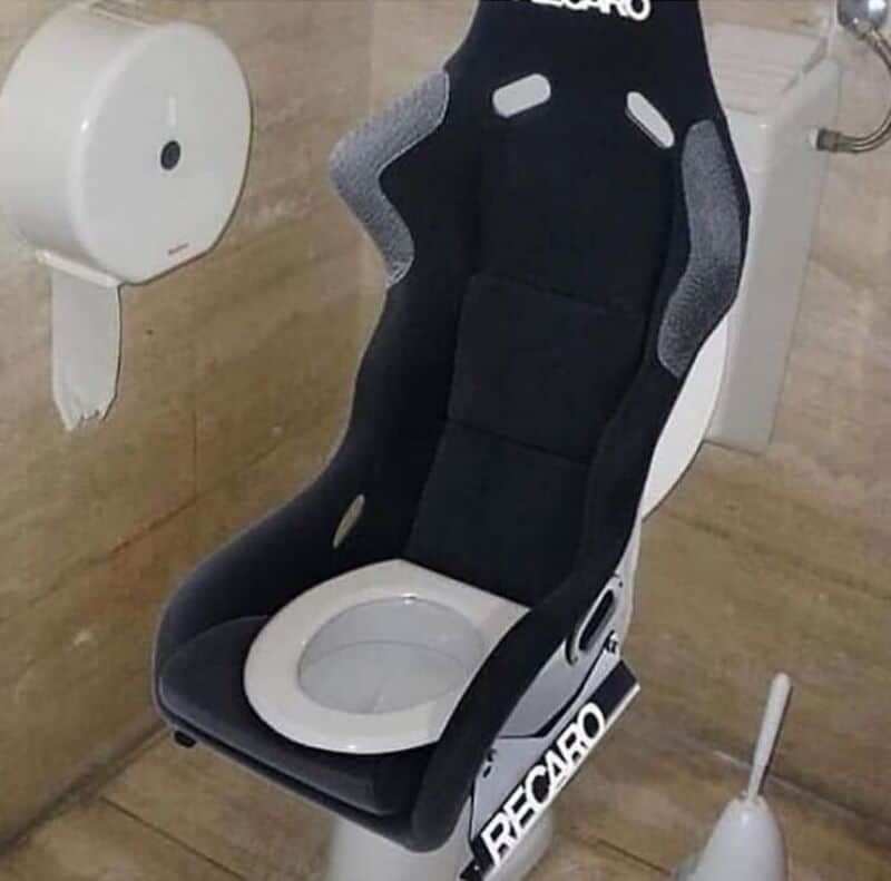 Racing seat installed on a toilet in a bathroom.