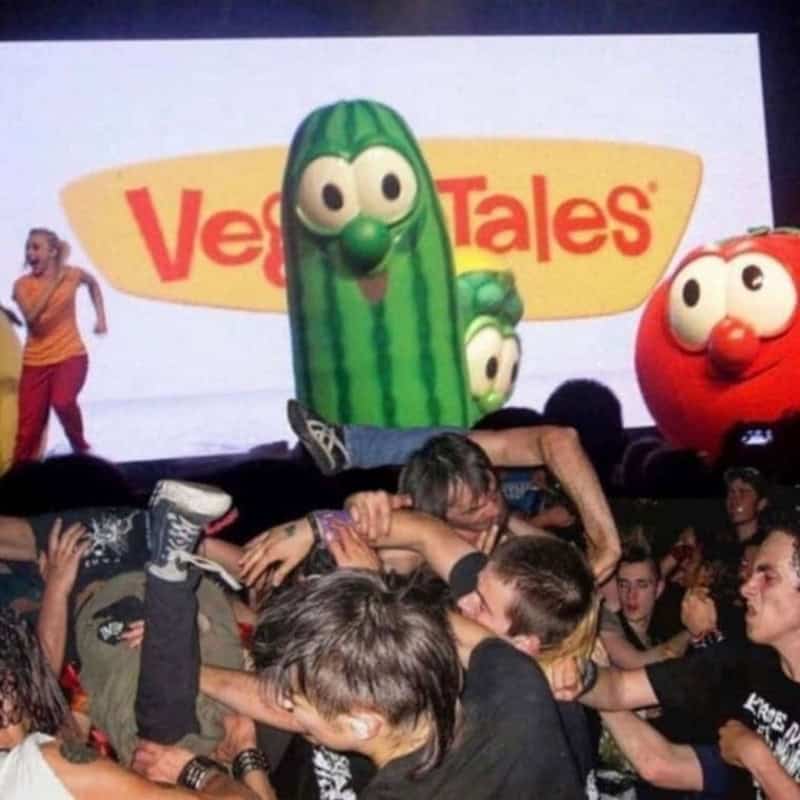 Kids fighting at VeggieTales event with large cartoon vegetable characters in background.