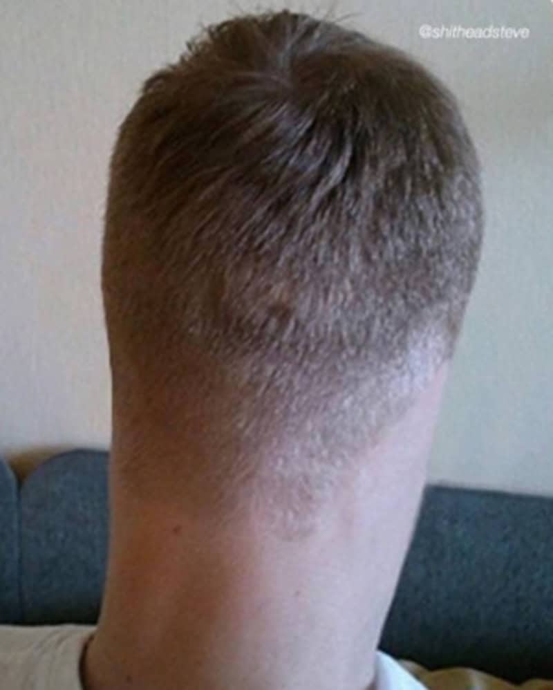 Back of a person's head with uneven haircut, longer on top and faded on sides.