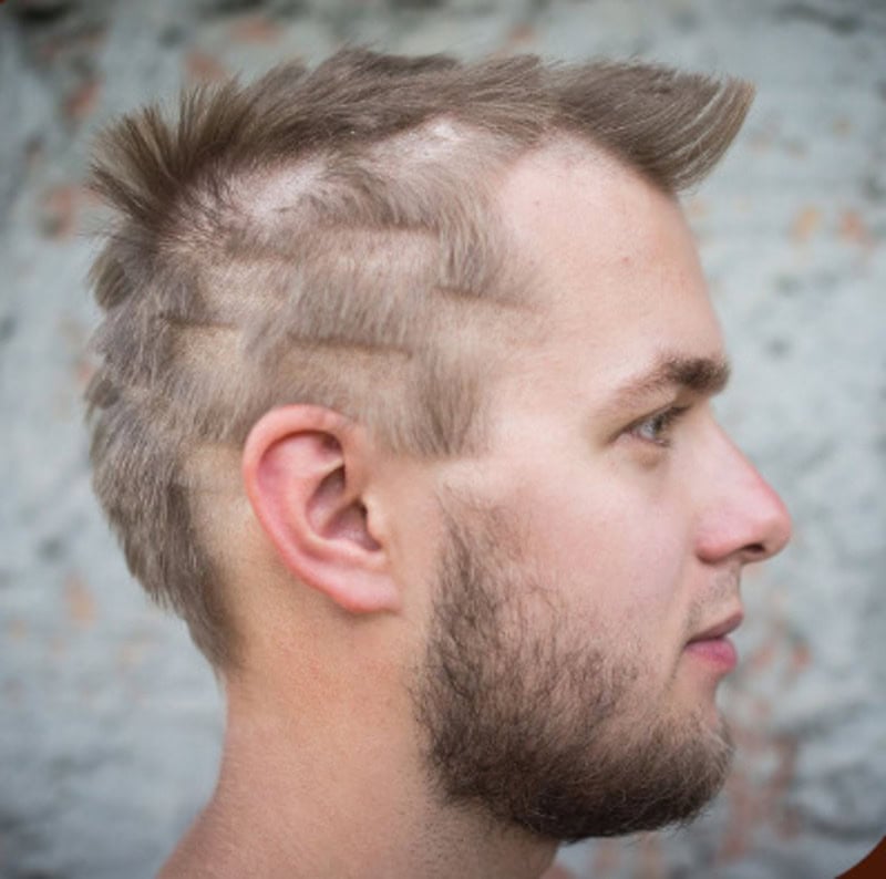 Side view of a man with a poorly done mohawk hairstyle and uneven haircuts.