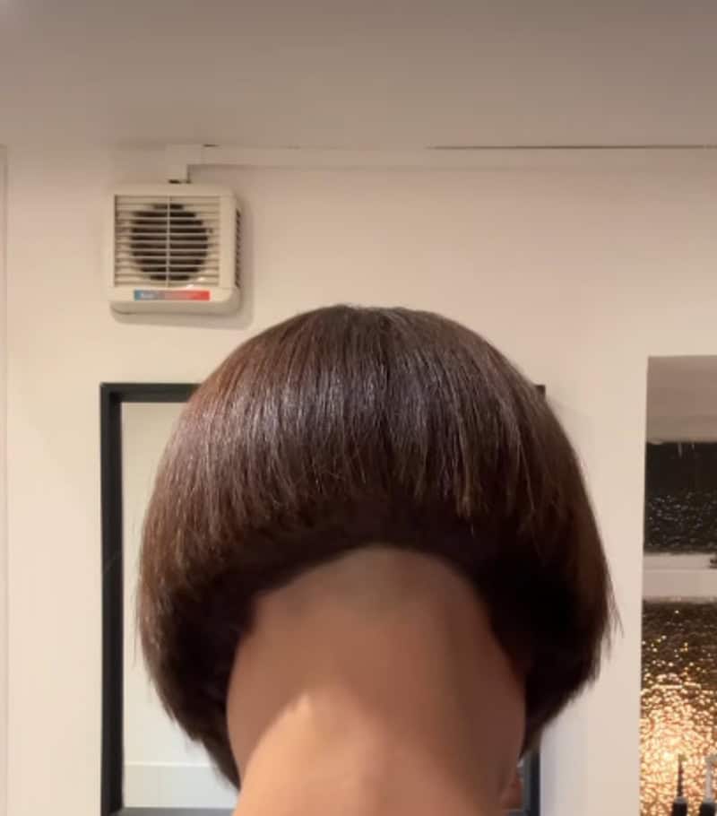 Haircut fail with uneven, rounded hair shape and a bald spot at the back.