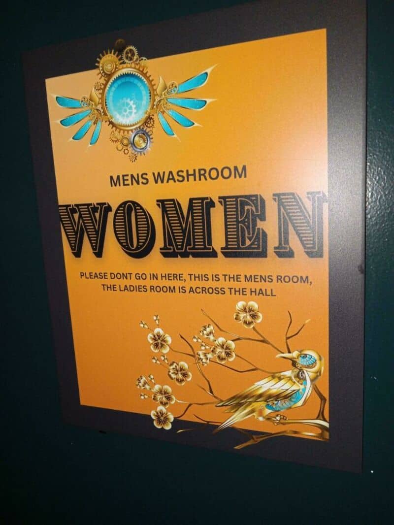 Sign for men's and women's washrooms with humorous instructions and decorative design.