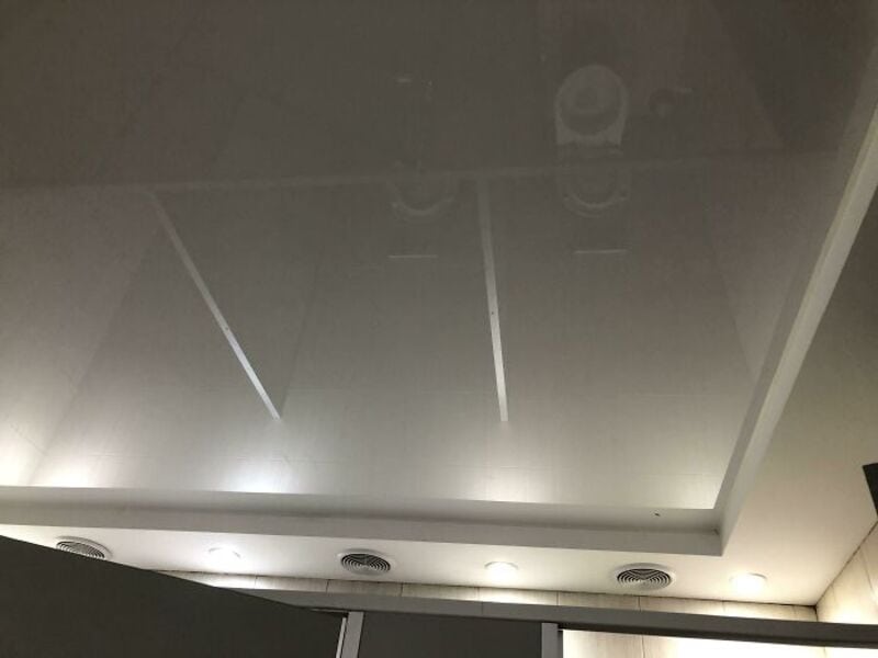 Ceiling with recessed lights and air vents in a bathroom.