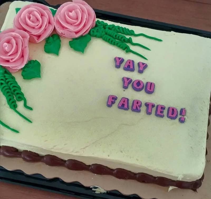Cake with pink roses and "YAY YOU FARTED!" message in purple letters.