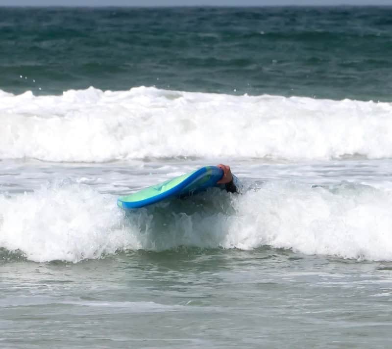 Person with a surfboard in the ocean waves.