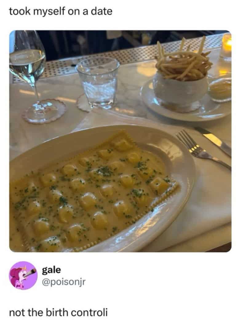 Creamy ravioli dish with herbs, a glass of white wine, a glass of water, and a bowl of French fries.