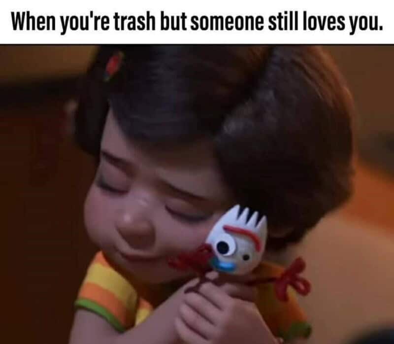 Child hugging a Toy Story character with a sad expression, caption about love despite being trash.