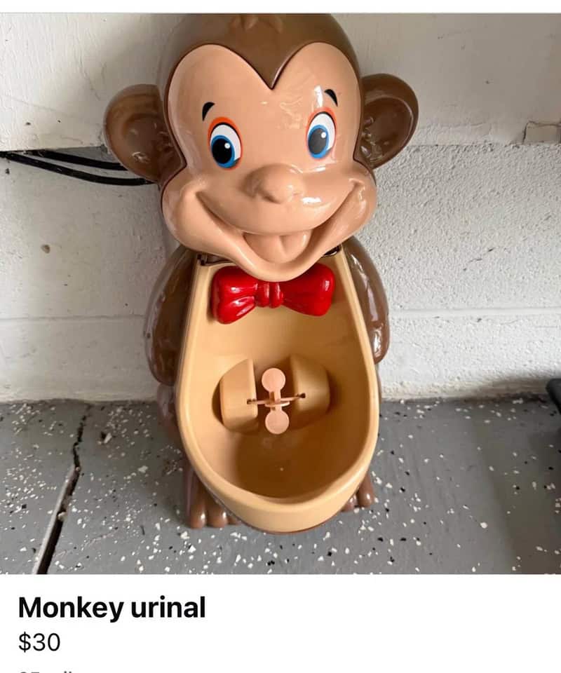 Monkey urinal toy with a smiling monkey face and red bow tie.