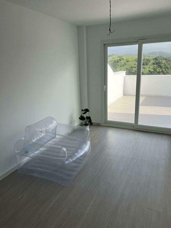 Modern room with transparent inflatable sofa and large balcony window.
