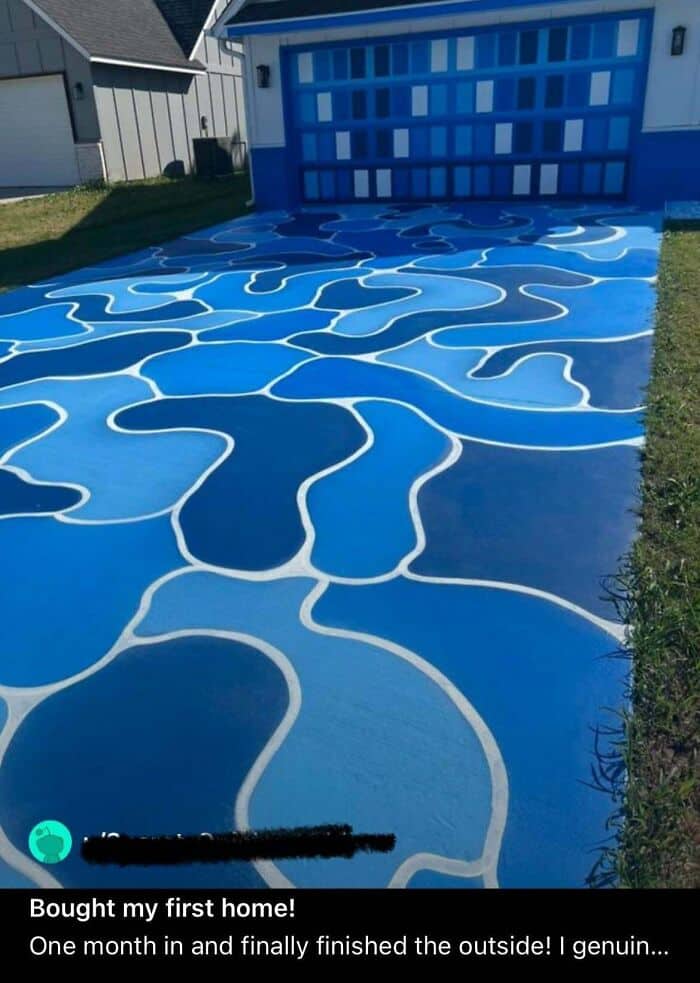 Blue abstract patterned driveway leading to a garage with a matching blue door.