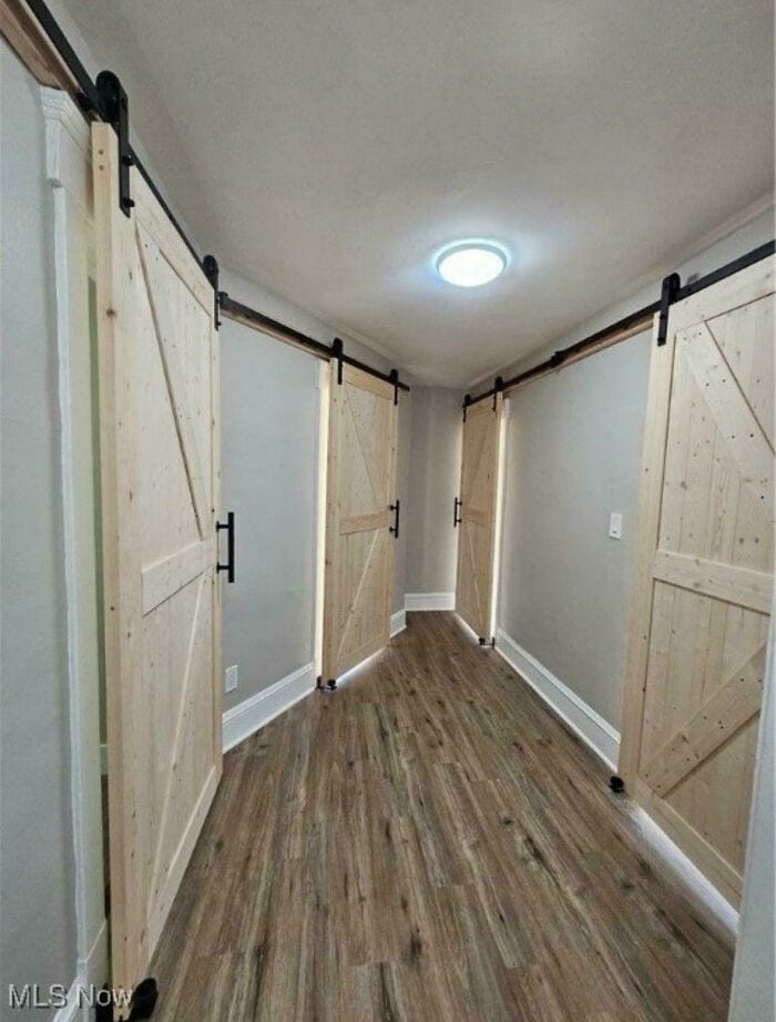 Corner of a hallway with wooden barn-style sliding doors on both sides.