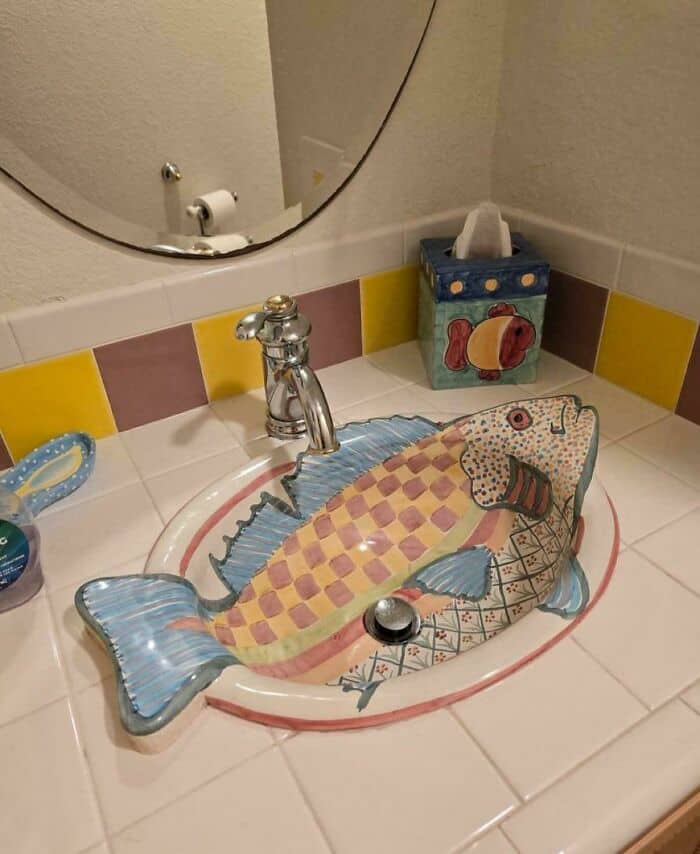 Fish-shaped sink with a checkered pattern, blue fins, and a pink outline.