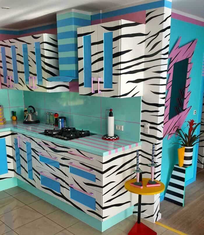 Bright, colorful kitchen with zebra stripe pattern, pink accents, and turquoise cabinets.