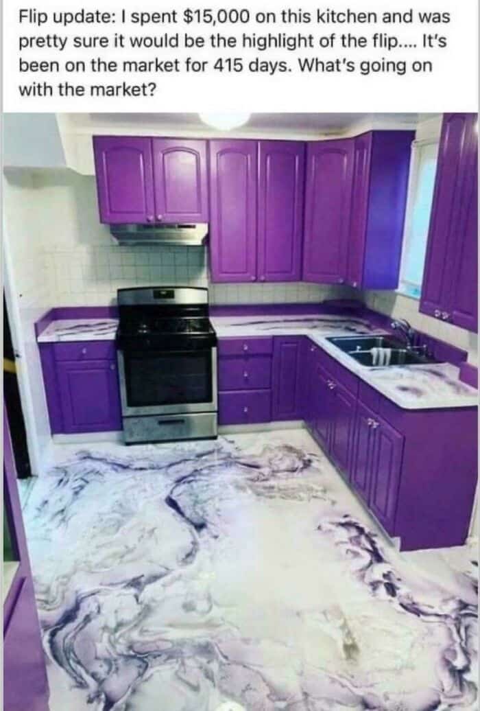 Purple kitchen with black stove, marble floor, and white countertops.