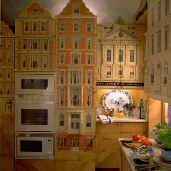 Miniature cityscape with detailed building facades and a kitchen setup.