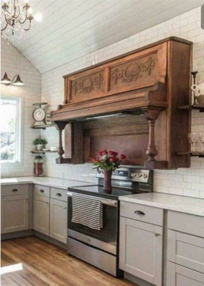 Vintage wooden wall-mounted cabinet above stove with carved details and a small shelf on the right.