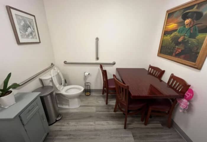 Small dining area with a table, chairs, and artwork on the wall.