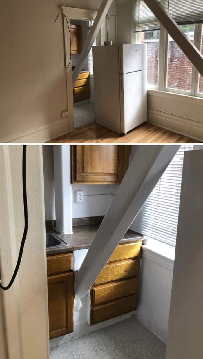 Small kitchen corner with white fridge and wooden cabinets near window.