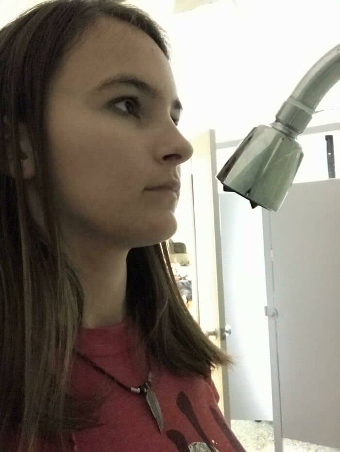 A woman looking through a microscope in a laboratory setting.