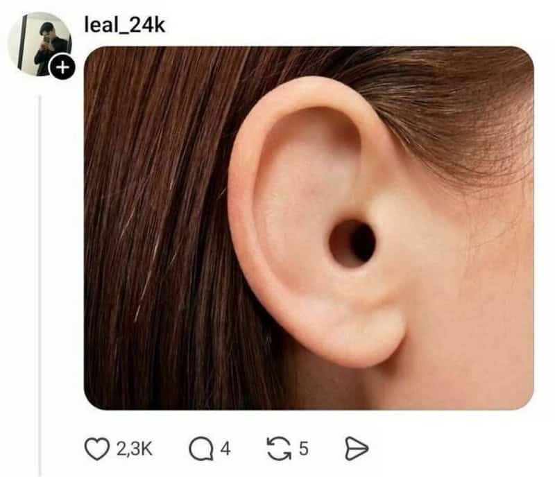 Close-up of a human ear with a small hole in the earlobe.