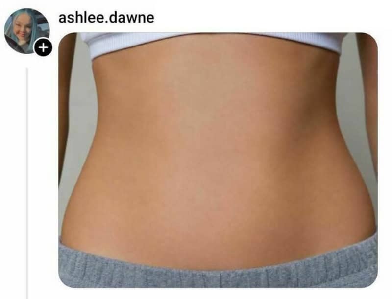 Close-up of a person's midsection showing smooth, toned skin and a white top.