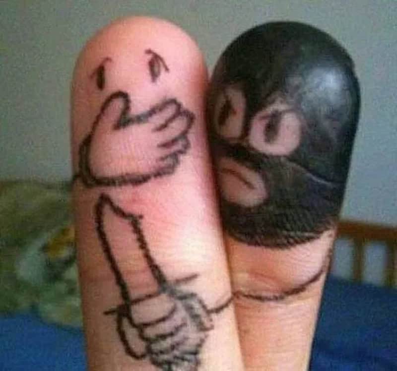 A finger with a drawing of a face and hand, and another finger with a drawing of a face and hair.
