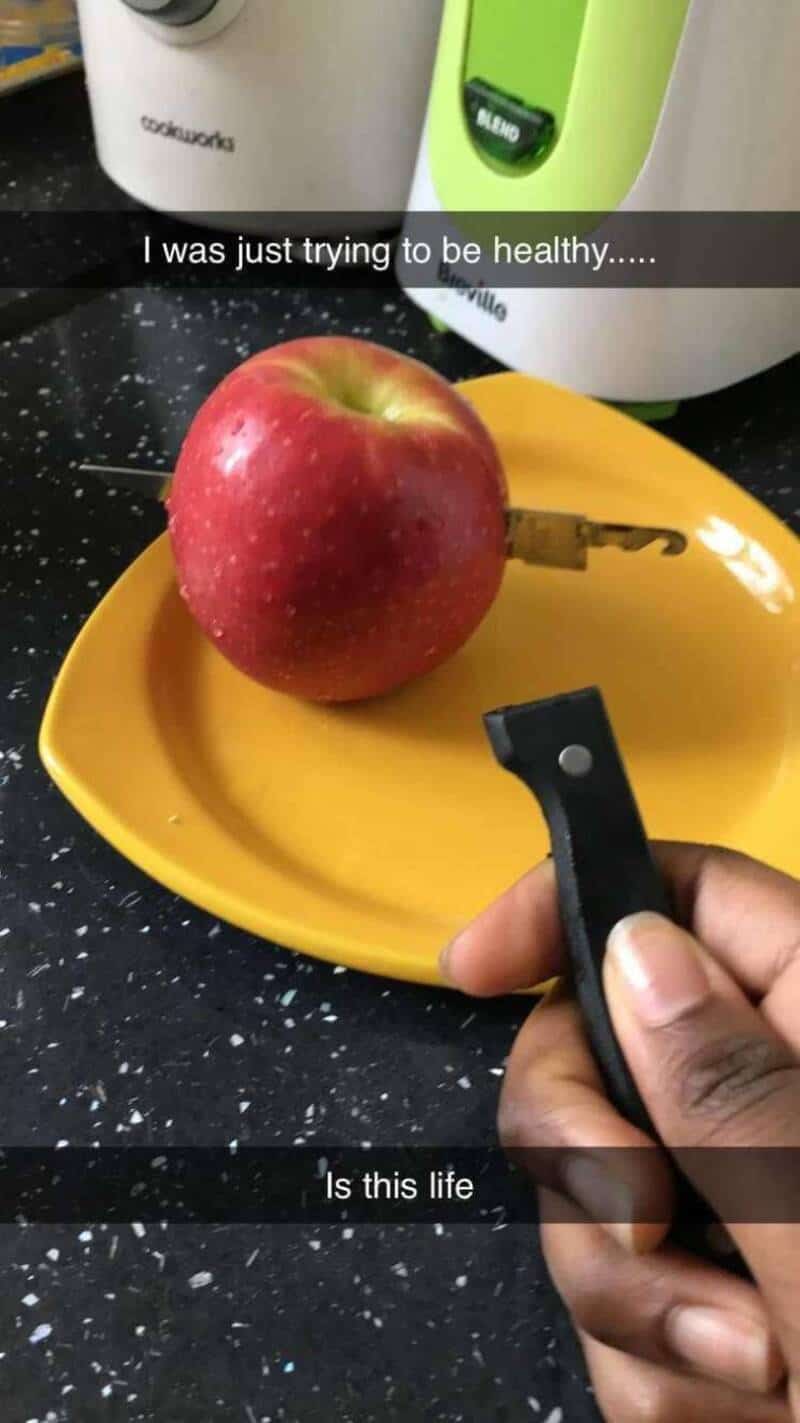 Apple on yellow plate with key, kitchen appliances in background.