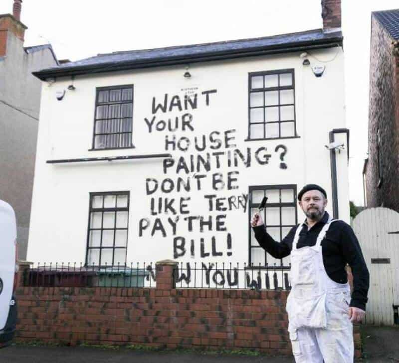 "Want your house painting? Don't be like Terry pay the bill!" graffiti on a white building with a ma.