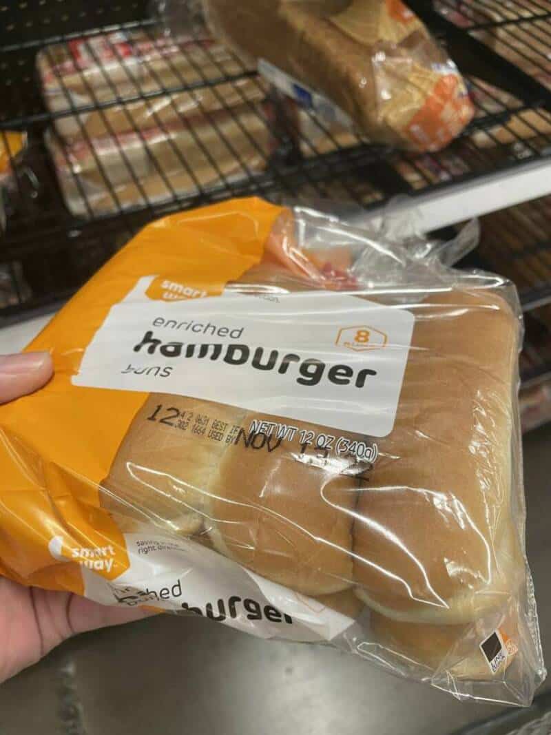 Enriched hamburger bun in clear plastic packaging on a store shelf.