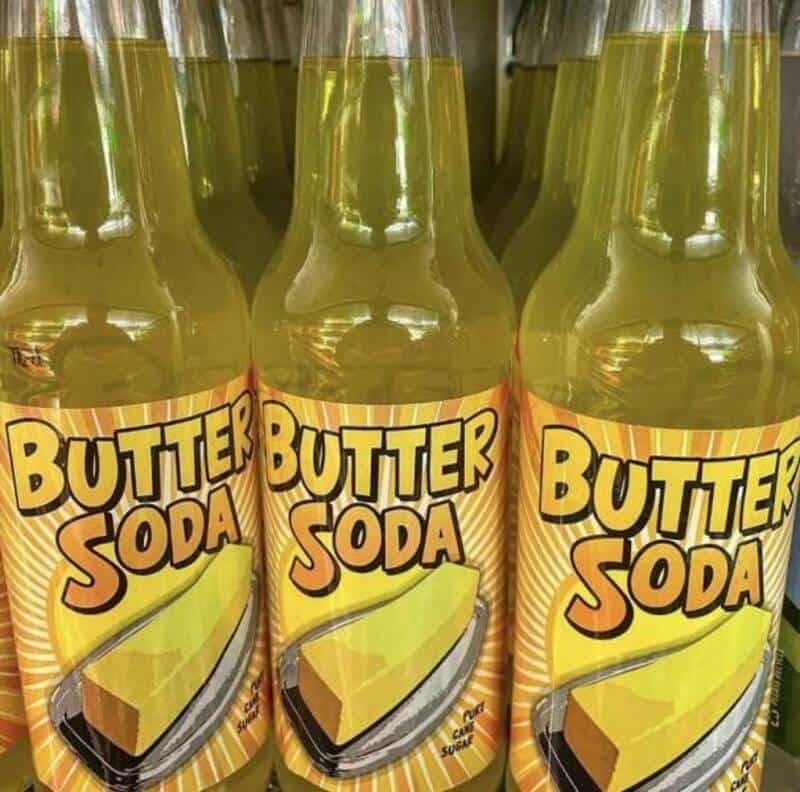 "Butter Soda" bottles with a yellow label and a slice of butter on a plate.