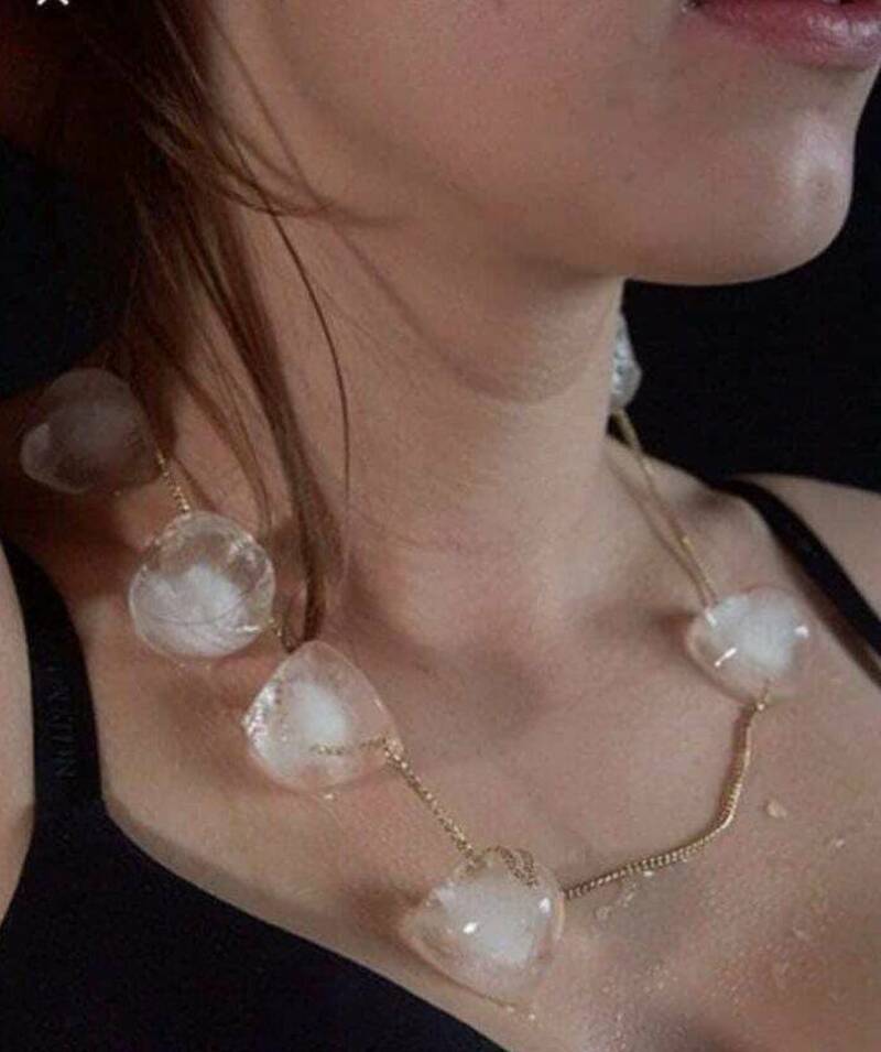 Woman wearing a necklace with large clear heart-shaped beads.