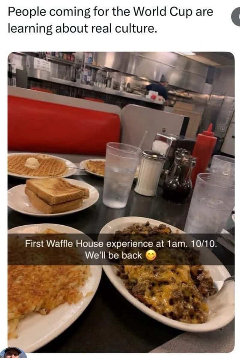A table with waffles, pizza, drinks, and condiments in a restaurant.