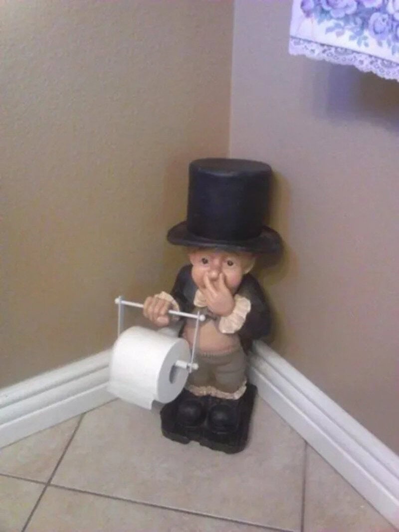 Cute figurine of a boy with a top hat holding a toilet paper roll on a stick.