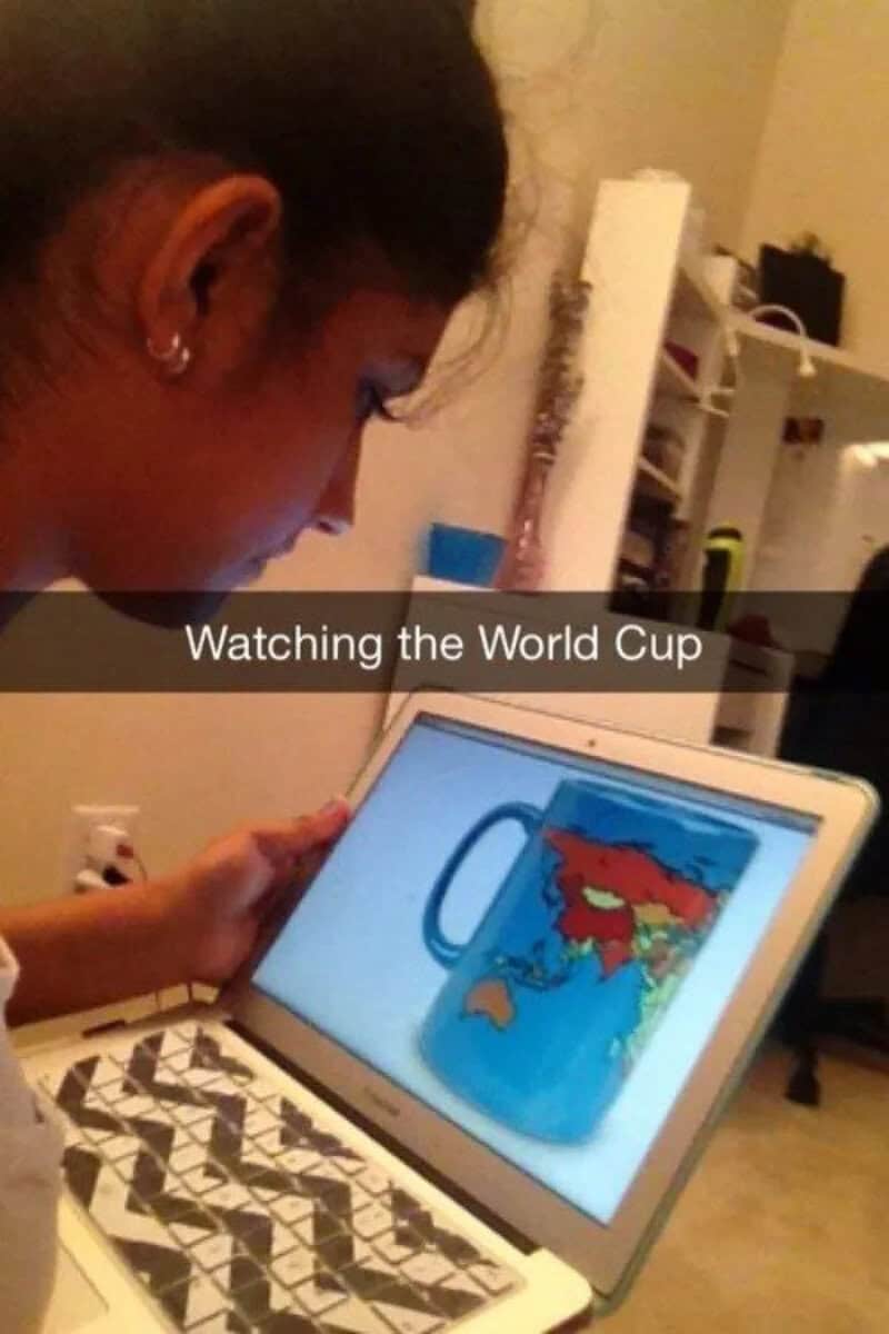 Girl watching the World Cup on a tablet with a cartoon mug image.