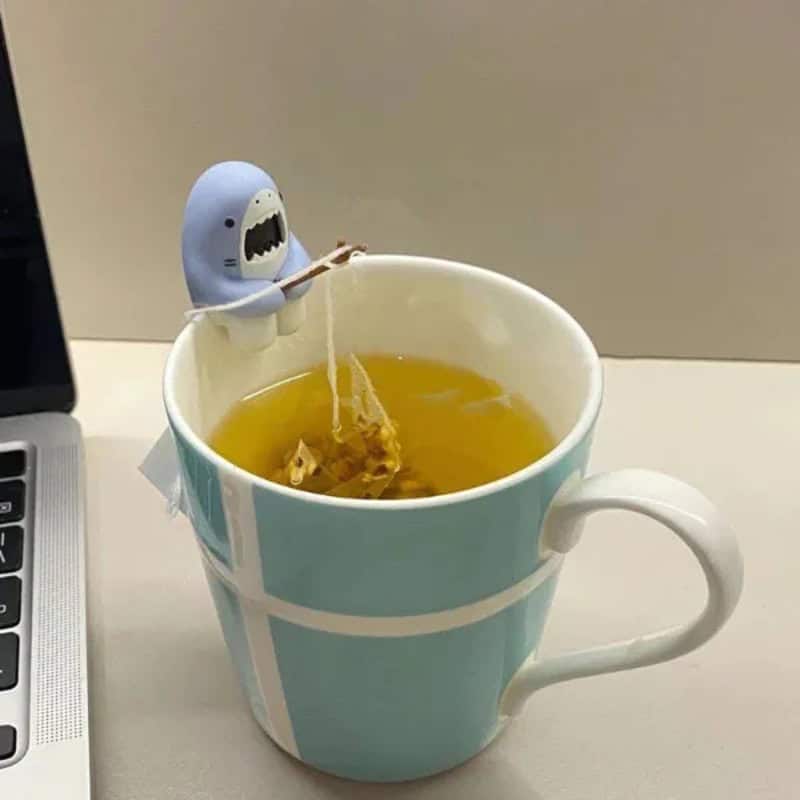 Cute shark figurine fishing tea bag in a mug of tea.