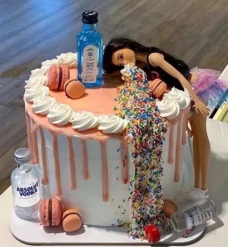 Doll lying on cake with spilled sprinkles, vodka, and macarons, birthday scene.