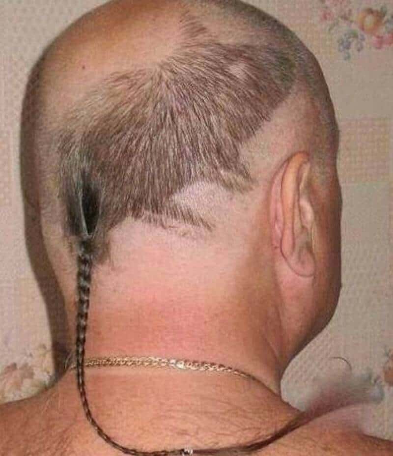 Back of a man's head with a braid and a shaved design on the scalp.