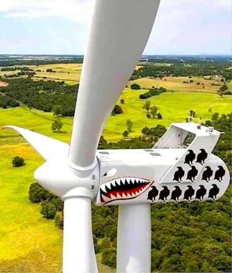 Wind turbine with a painted shark face and black silhouettes of dogs.