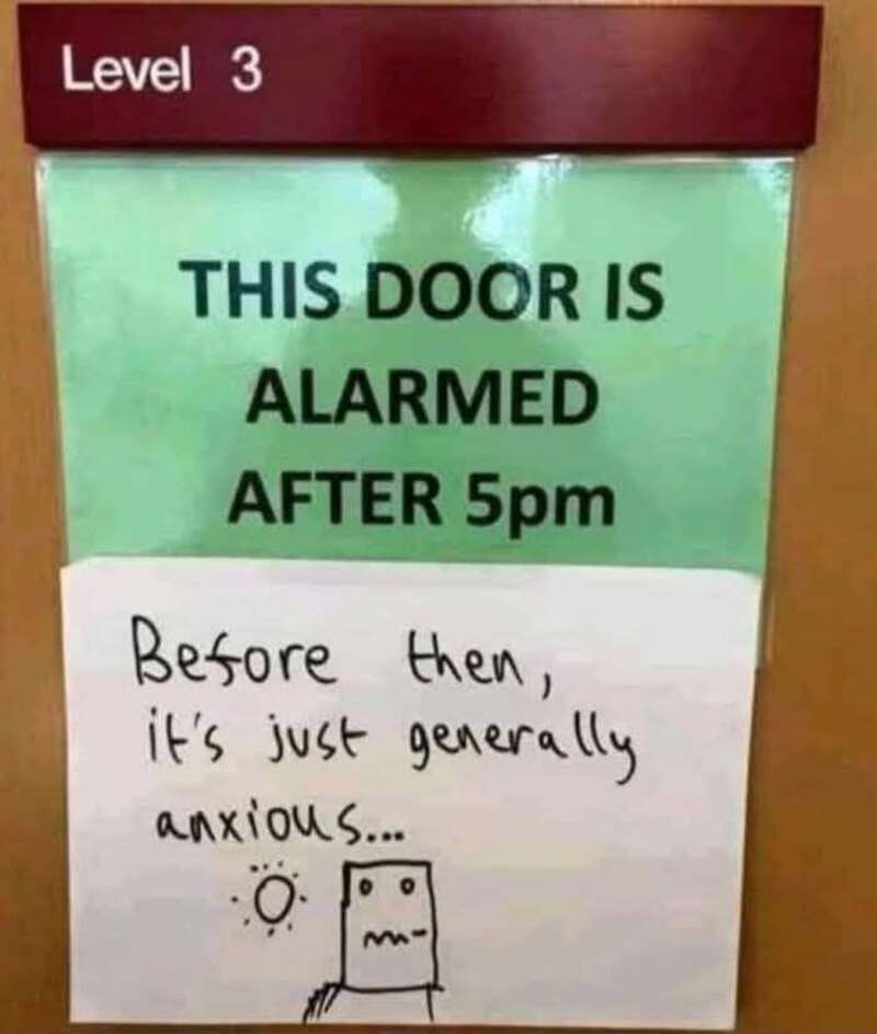 Sign says 'This door is alarmed after 5pm' with a handwritten note and drawing.