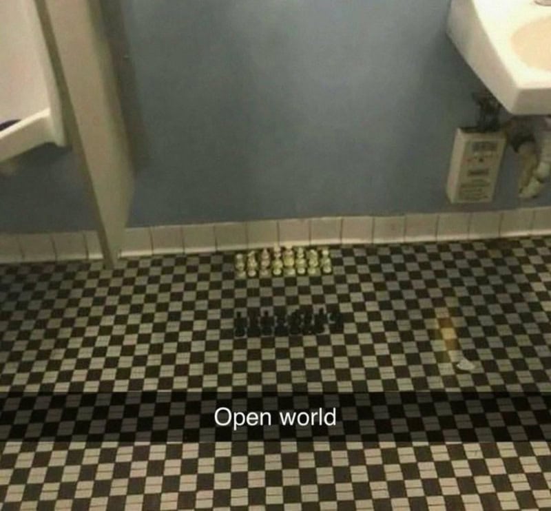 Chess pieces arranged on a checkered bathroom floor with 'Open world' text.