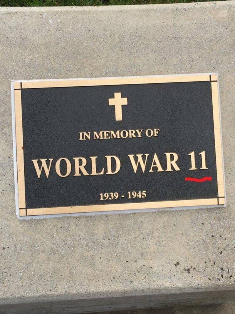 Plaque memorial for World War II with a cross and red mark.
