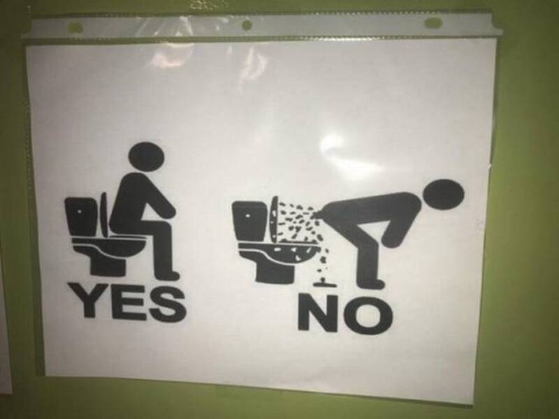 Sign showing 'YES' for sitting and 'NO' for urinating in toilet.