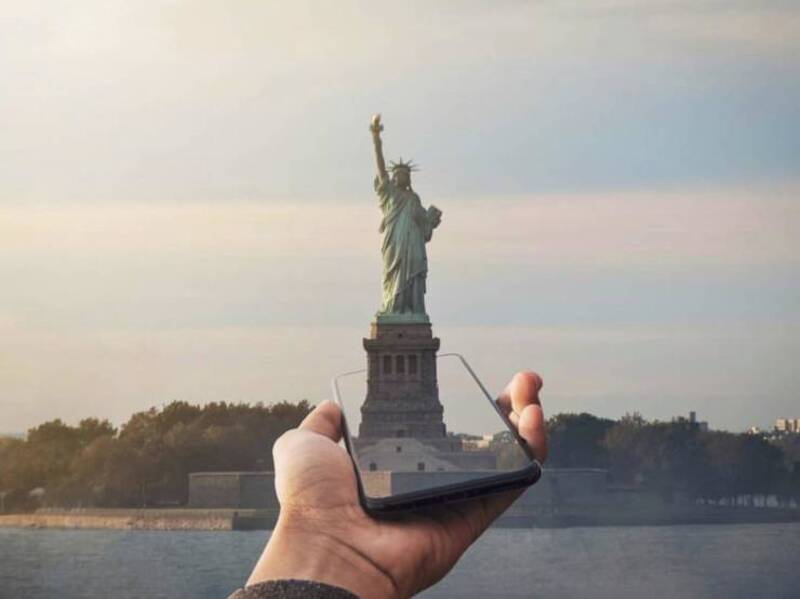 Person holding a phone with the Statue of Liberty on the screen.