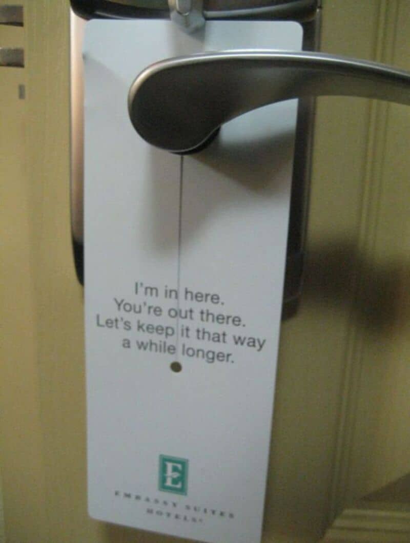 Door handle with a sign saying 'I'm in here. You're out there. Let's keep it that way a while longer.