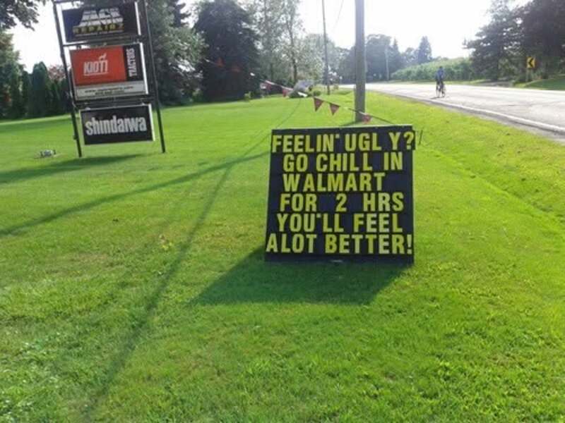 Signboard on grass with humorous message about Walmart and feeling better.