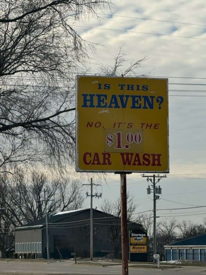 Sign asking 'Is this heaven?' and saying it's a car wash for $1.00.